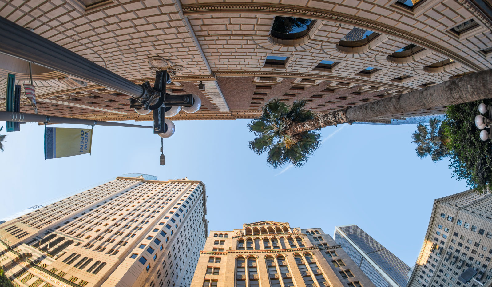 A fish-eye view looking up at tall classical buildings in Downtown Los Angeles Financial District