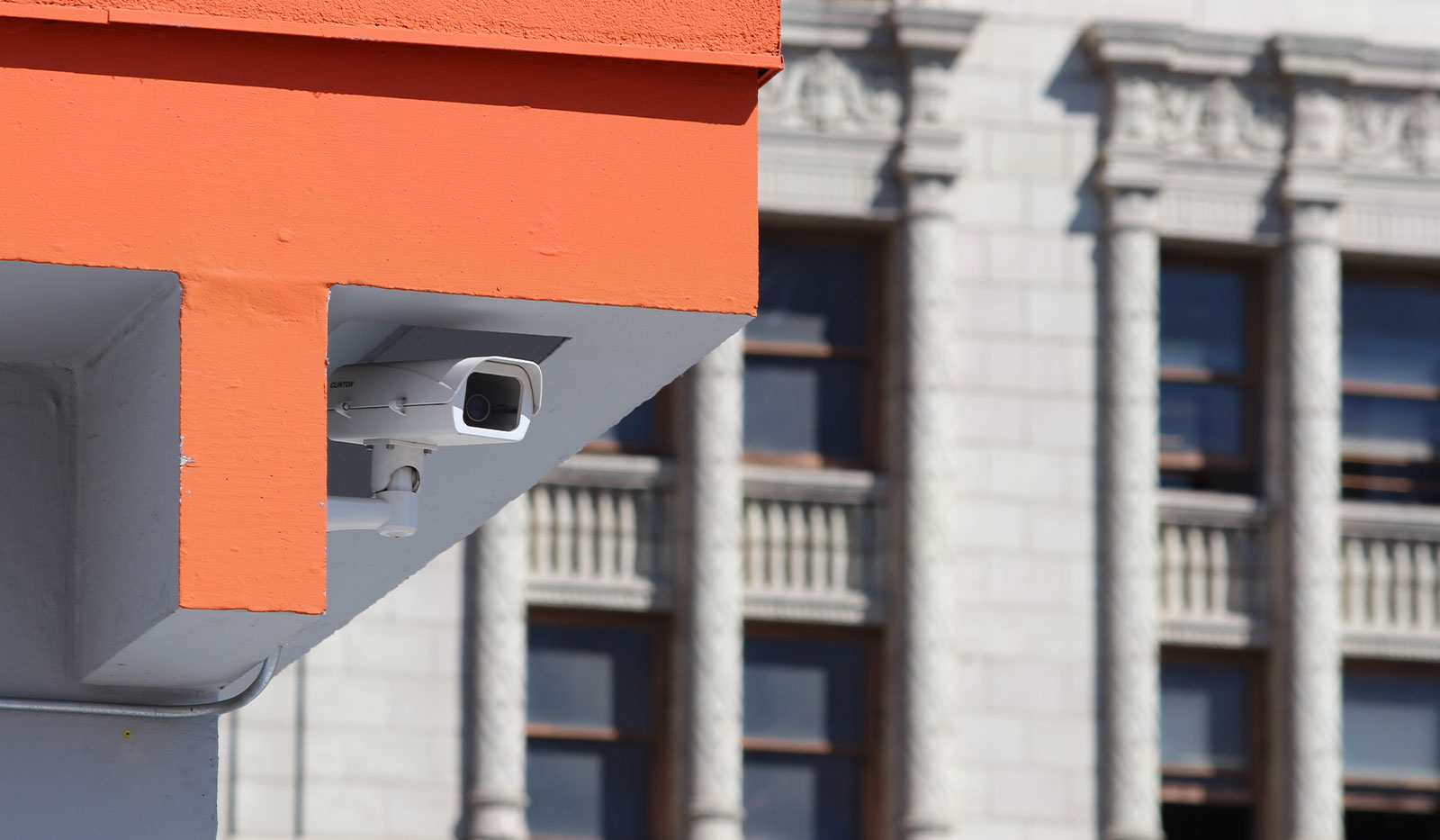 Security camera ucked into roof of parking structure with pre-war DTLA buildings in the background