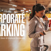 Business woman in parking garage by her car, laughing on phone